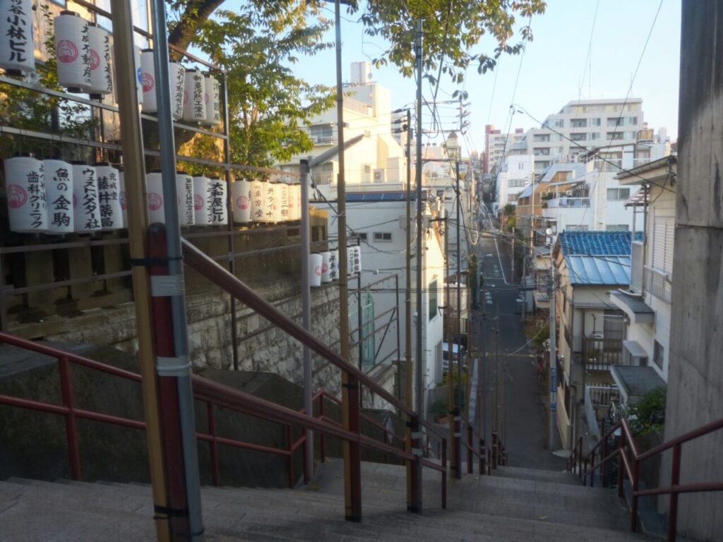 alt="The iconic red-railed staircase at Suga Shrine in Tokyo, featured in the anime Your Name"